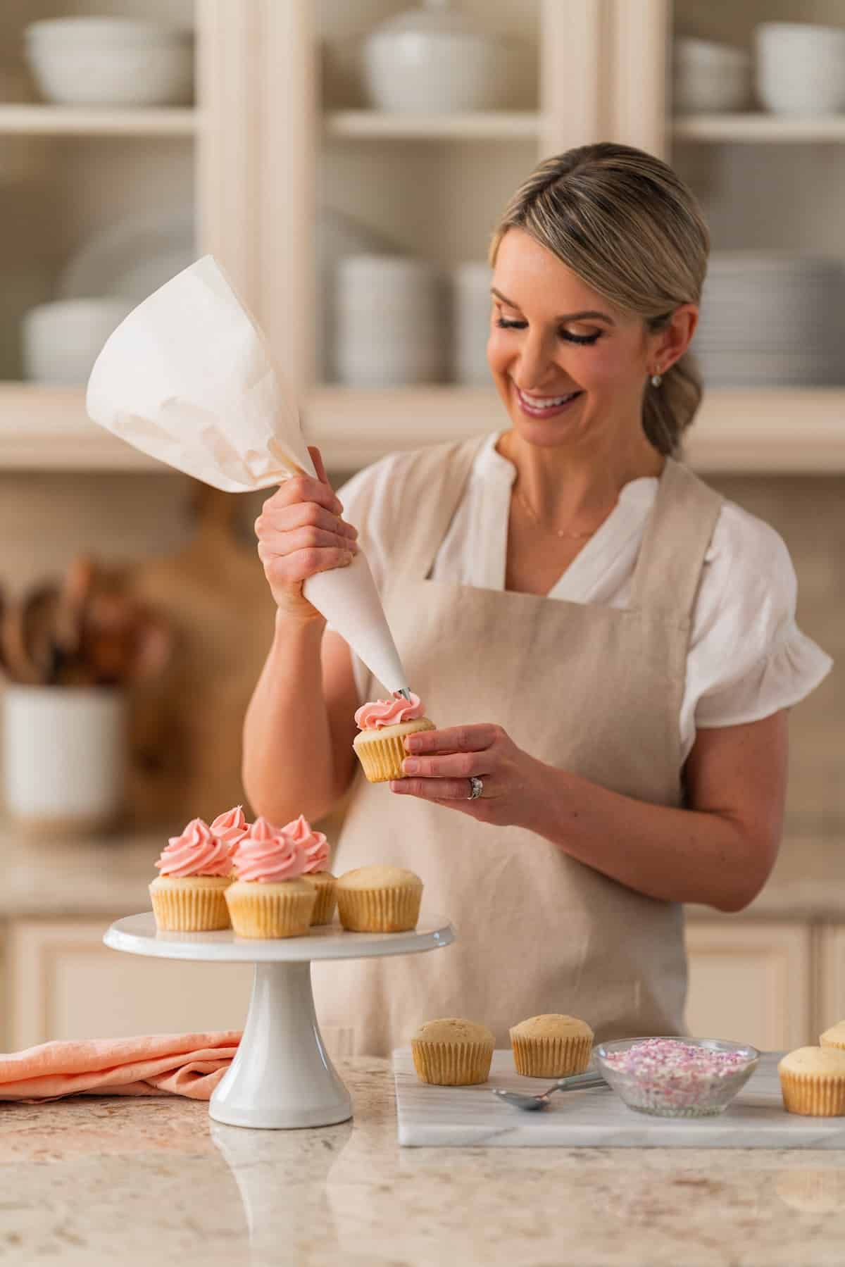 Sally piping cupcakes in her kitchen