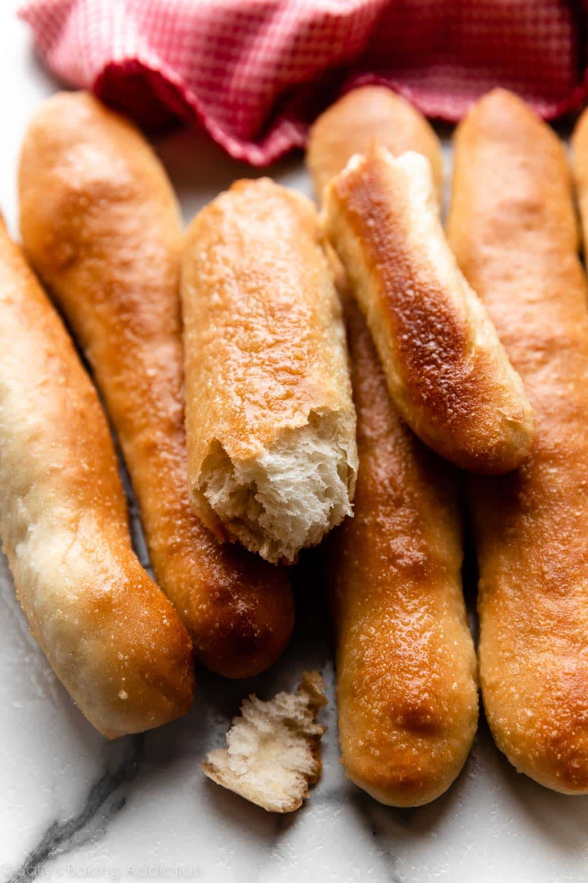 breadsticks on marble counter with red linen in background.