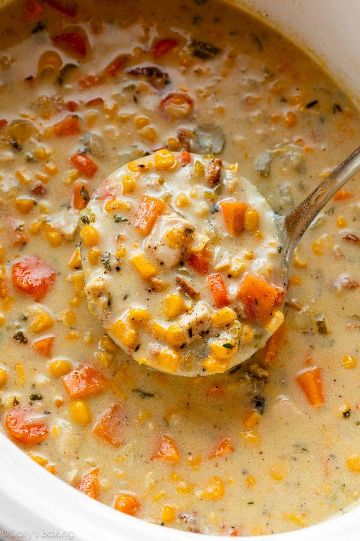 ladle of creamy chicken and corn soup in slow cooker.